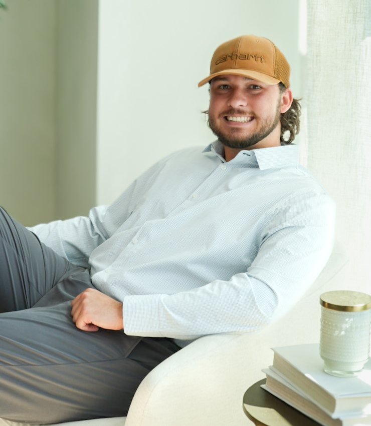 Gage Cornell, owner of NGAGED, smiling in a white armchair